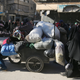 Aleppo residents walk with their belongings as they gather to be evacuated. (Reuters/Abdalrhman Ismail)